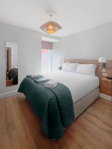 a bedroom with a large bed with a green blanket at Madelines Accommodation in Tinahely