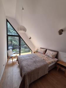 a bedroom with a bed and a large window at Fale i Igły in Sasino +30 photos