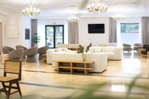 ein Wohnzimmer mit weißen Sofas und Sesseln in der Unterkunft Checkin Valencia Ciscar in Picanya