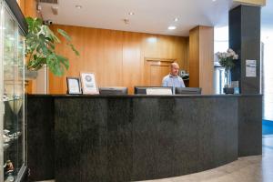 Ein Mann steht an der Rezeption eines Hotels. in der Unterkunft Checkin Valencia Ciscar in Picanya + 49 Fotos