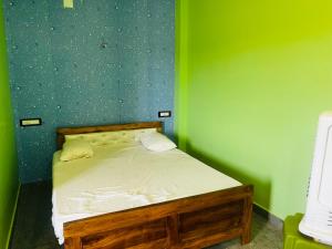 a small bedroom with a bed with green walls at Aman Convention in Chāndbāli +13 photos