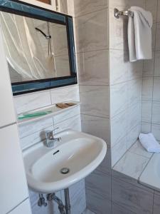 a white bathroom with a sink and a mirror at Gästehaus Gartenstraße 5 vom Central Hotel in Schwetzingen +31 photos