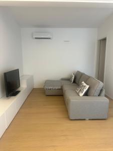 a living room with a couch and a tv at Appartamento Stella - 15' walk to Abano Terme centre in Abano Terme