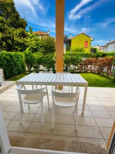 a white table and chairs on a patio at Appartamento Stella - 15' walk to Abano Terme centre in Abano Terme +2 photos