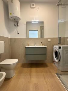 a bathroom with a sink and a toilet and a mirror at Appartamento Stella - 15' walk to Abano Terme centre in Abano Terme