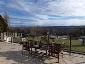 a patio with a table and chairs on a balcony at Le Cocon Des Roches in Cessieu +2 photos