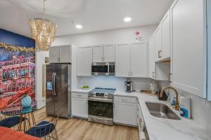 a kitchen with white cabinets and stainless steel appliances at Tiger Lily in Nashville