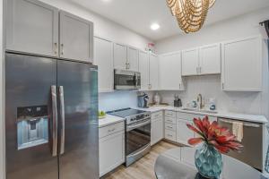 a kitchen with white cabinets and a stainless steel refrigerator at Tiger Lily in Nashville