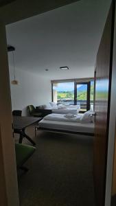 two beds in a room with a large window at Refugium.311 in Bad Reichenhall