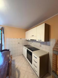 a kitchen with white cabinets and a stove top oven at CASA SAN MICHELE in Bovegno +8 photos