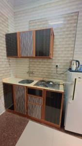 a small kitchen with a sink and a refrigerator at السلطان هاوس in Najran