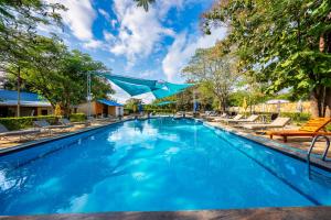 a swimming pool with lounge chairs and a blue at Tan-Swiss Lodge in Mikumi