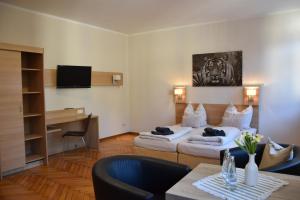 a living room with two couches and a television at Pension Alte Flugleitung in Stendal