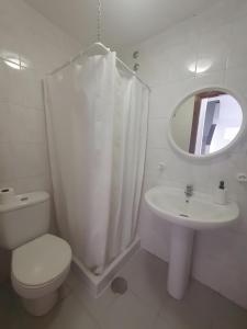 a white bathroom with a toilet and a sink at Duplex Beach Cabezo 2h terrace in El Médano +9 photos