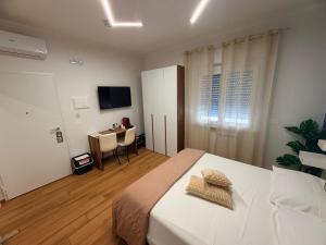 a bedroom with a bed and a desk and a television at Palazzo del Toro 2 in Montesilvano