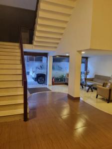 a living room with a staircase and a living room with a couch at Hotel Holiday Park,Thalassery in Green Island