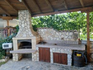 an outdoor kitchen with a stone oven in a patio at Zenith Guest House in Sozopol