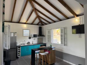 a kitchen with blue cabinets and a black counter at Freedom House in Le Diamant