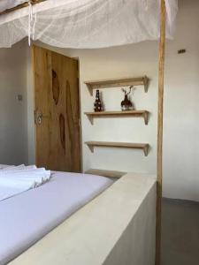 a bedroom with a bunk bed with a white bedspread at Mambo Leo Hostel in Paje +12 photos