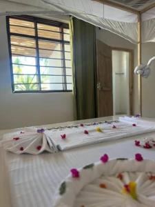 a bedroom with a bed with flowers on it at Mambo Leo Hostel in Paje