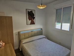 a bedroom with a bed and a window at O Alpendre in Bueu