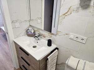 a white bathroom with a sink and a mirror at O Alpendre in Bueu +11 photos