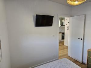 a white room with a flat screen tv on a wall at O Alpendre in Bueu