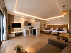a hotel room with two beds and a living room at Prukrom Lanta Villa in Ko Lanta