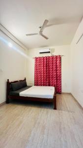 a bedroom with a bed and a red curtain at Maxi villa maamalla in Mahabalipuram +16 photos