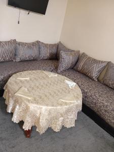 a couch with a table with a white table cloth at Dar Al Medina in Casablanca