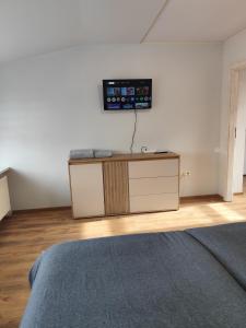 a room with a bed and a tv on a wall at Centro-loftas in Telšiai