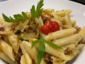 a plate of pasta with a tomato on top at Villa Franca Luxury Chalets in Sighişoara +7 photos