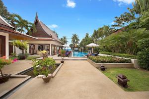 a house with a courtyard with a pool and some plants at Dhevatara Cove in Lipa Noi