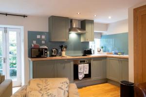 a kitchen with green cabinets and a stove top oven at Newton Cottage South in Inveraray +18 photos