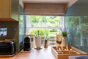 a kitchen with a window and a counter with boxes at Newton Cottage South in Inveraray