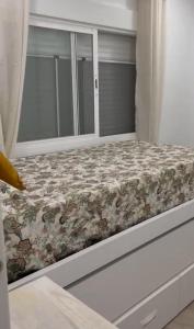 a bed in a room with a window at Apartamento Hércules in Ceuta
