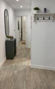 a living room with a wooden floor and a mirror at Apartamento Hércules in Ceuta