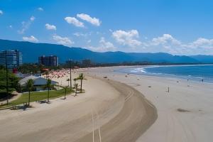 a beach with people on it and the ocean at Suítes confortáveis próximo ao Sesc in Bertioga