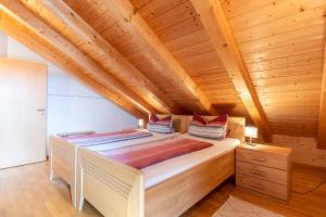 a large bed in a room with wooden ceilings at Kramerhof - Ferienwohnung Wallberg in Aufhofen