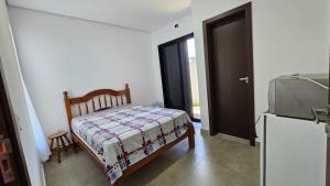 a small bedroom with a bed and a television at Suítes Ninho dos Lobos in Pardinho