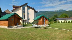 a house with two wooden buildings in a yard at Vojinov kutak in Mojkovac