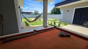 a backyard with a pool table and a hammock at Suítes Ninho dos Lobos in Pardinho