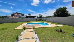 a backyard with a swimming pool in the grass at Suítes Ninho dos Lobos in Pardinho