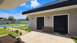 a house with a bench and a swimming pool at Suítes Ninho dos Lobos in Pardinho