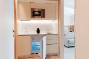 a kitchen with a sink and a microwave at PALAZZO RUBINO Aparthotel in Olbia