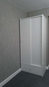 a white cabinet in the corner of a room at Teodor Apartment in Budraičiai +6 photos