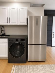 a kitchen with a refrigerator and a washing machine at Cozy Private Studio in Des Moines +3 photos