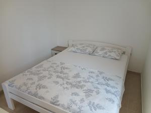 a bedroom with a bed with a blue and white comforter at Kumbor S in Herceg-Novi