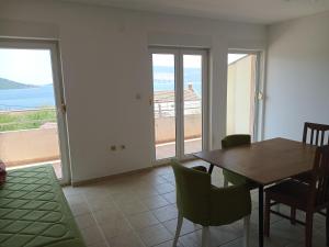 a dining room with a table and a view of the ocean at Kumbor S in Herceg-Novi