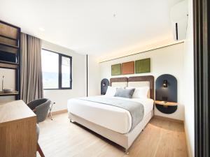 a hotel room with a bed and a desk at Blues Suites Laureles in Medellín